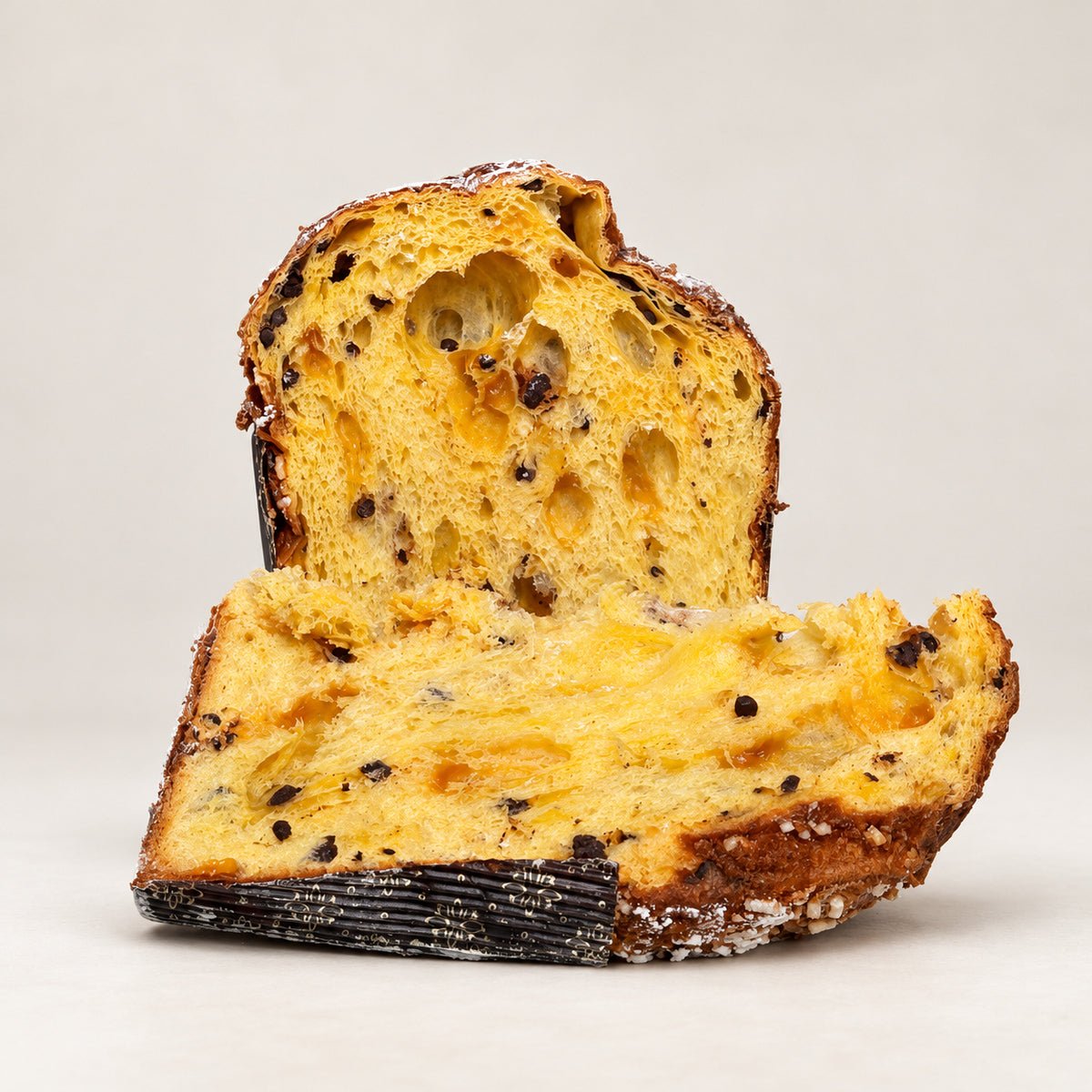 Panettone albicocca e cioccolato Librizzi Deluxe di SicilyAddict, tagliato con fetta su fondo chiaro