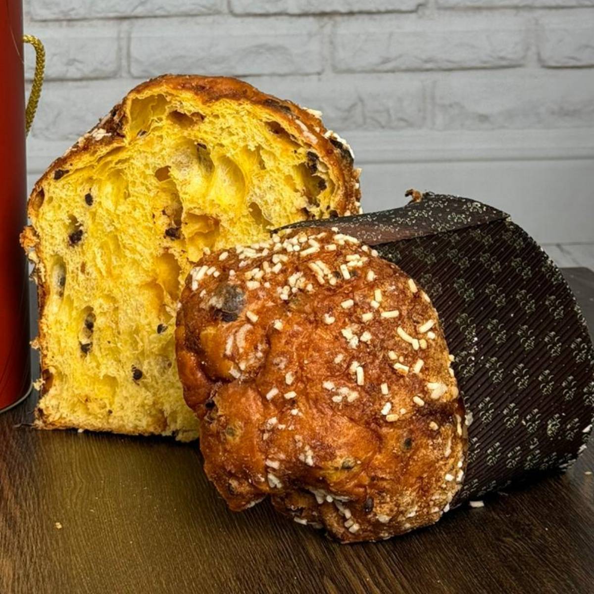 Panettone albicocca e cioccolato Librizzi Deluxe di SicilyAddict, dettaglio del taglio e della glassatura su tavolo di legno