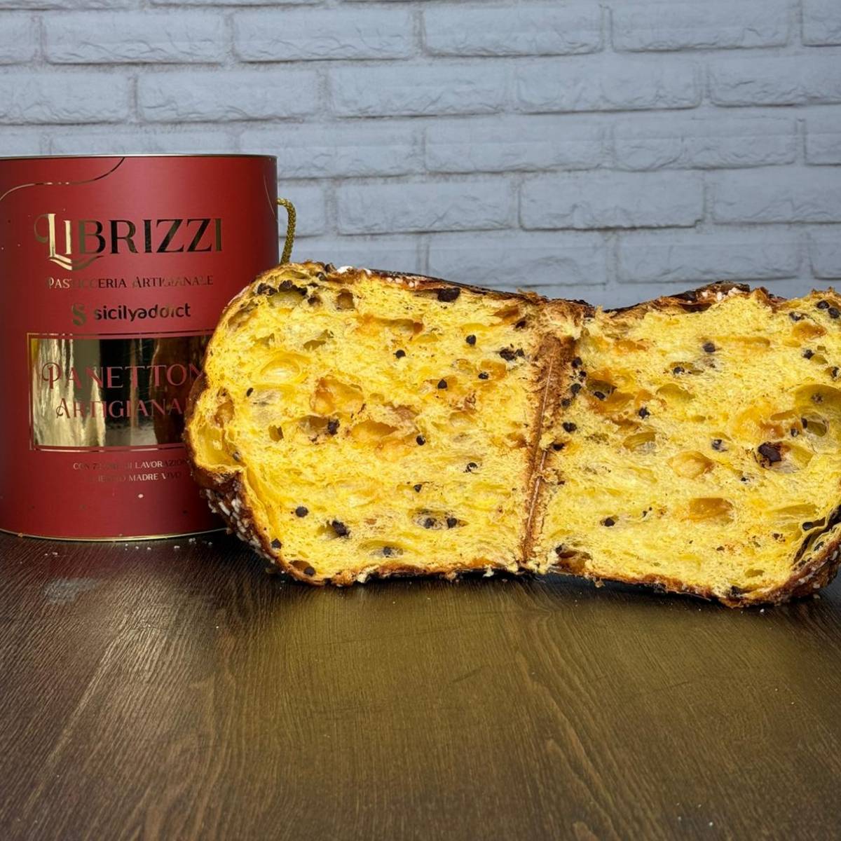 Panettone albicocca e cioccolato Librizzi Deluxe di SicilyAddict, aperto con confezione su tavolo di legno