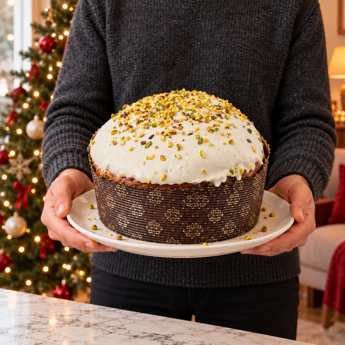 Panettone al cioccolato e pistacchio Ciokopistacchio tenuto in mano davanti alla tavola natalizia.