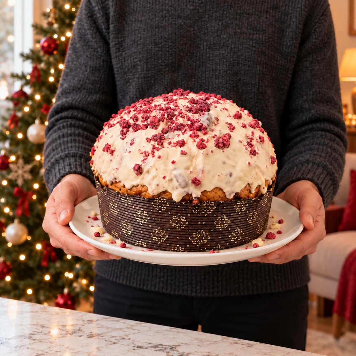 Panettone Frutti di Bosco e Cioccolato Bianco tenuto in mano davanti alla tavola natalizia.