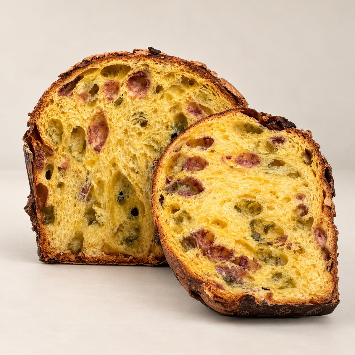Panettone pistacchio e lamponi Librizzi Deluxe di SicilyAddict, tagliato con fetta su fondo chiaro