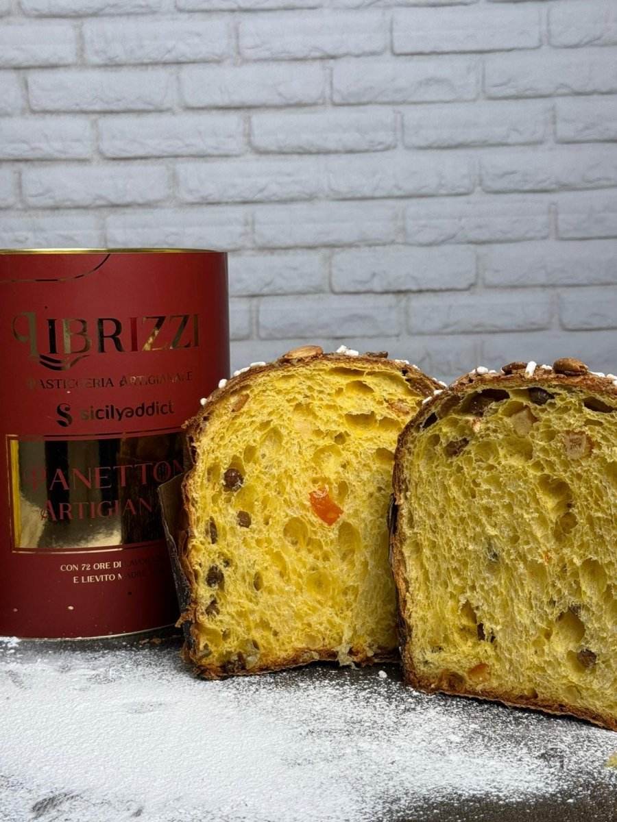 Panettone tradizionale Librizzi Deluxe di SicilyAddict, tagliato con confezione davanti a una parete bianca